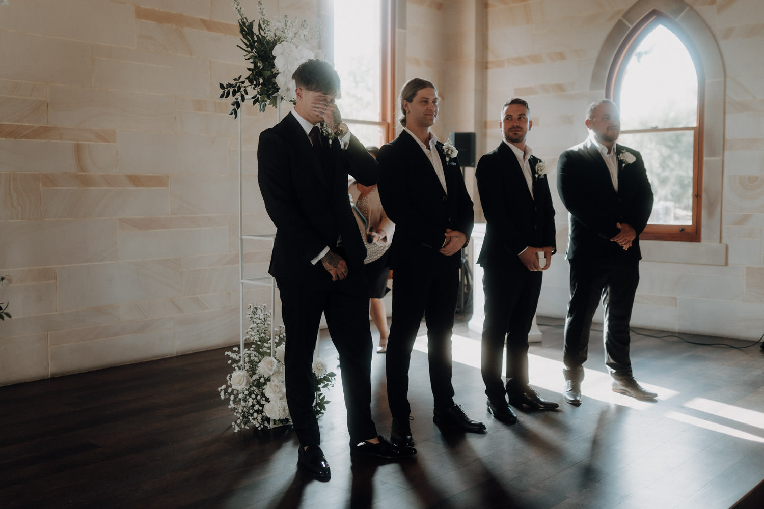 Bräutigam und seine Groomsmen in einer Kapelle.