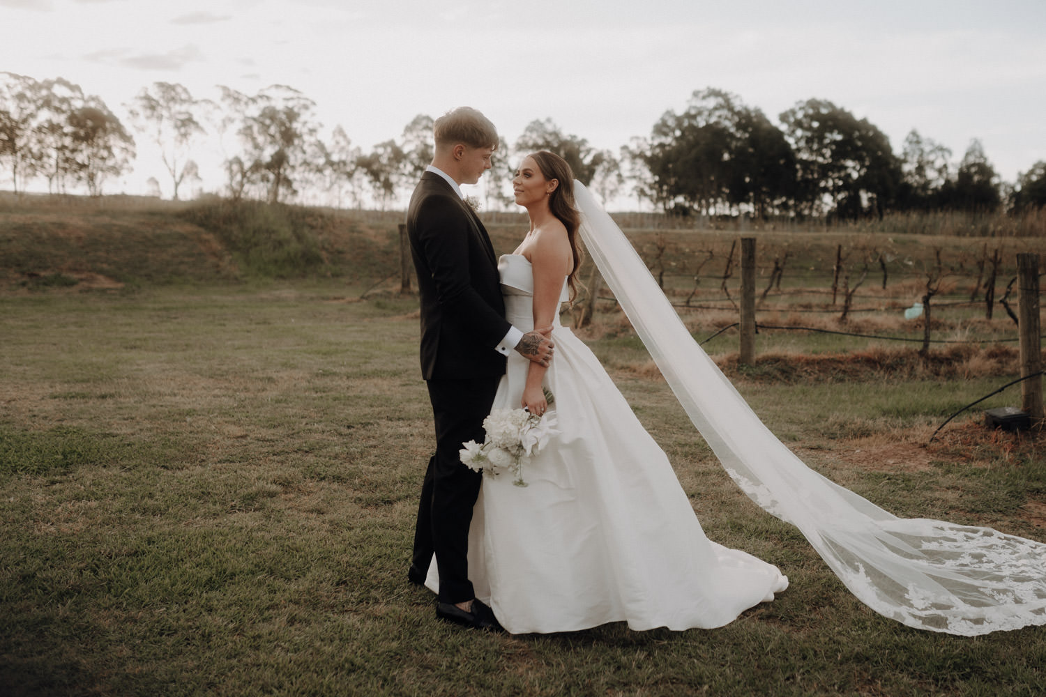 Ein Brautpaar steht neben Weinreben im Hunter Valley in Australien.