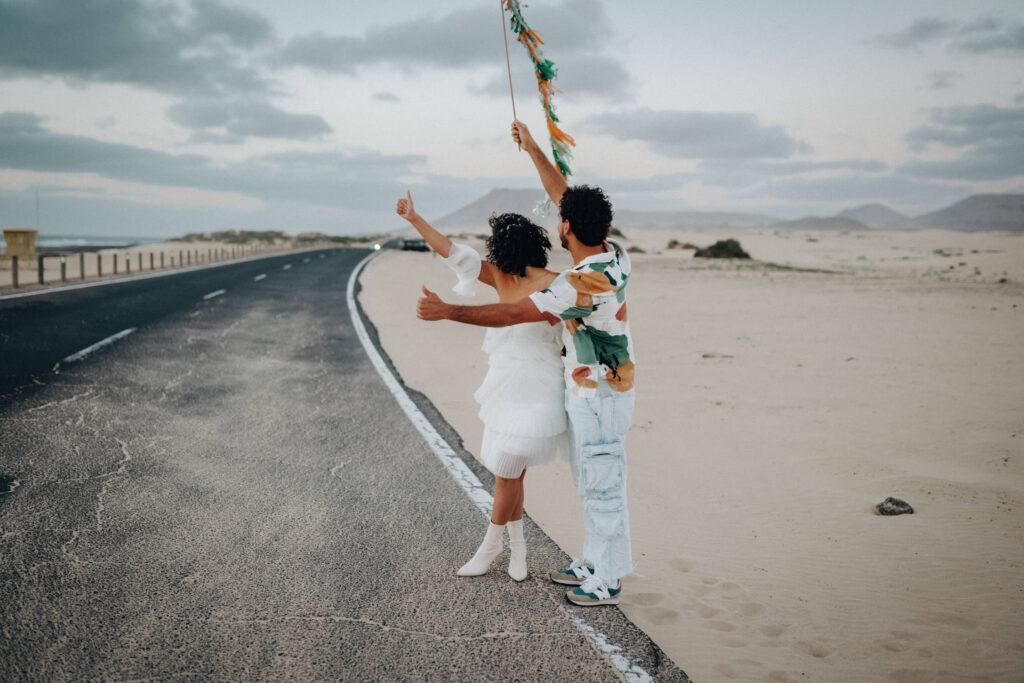 Ein Brautpaar steht im Morgengrauen an einer leeren Straße auf Fuerteventura.